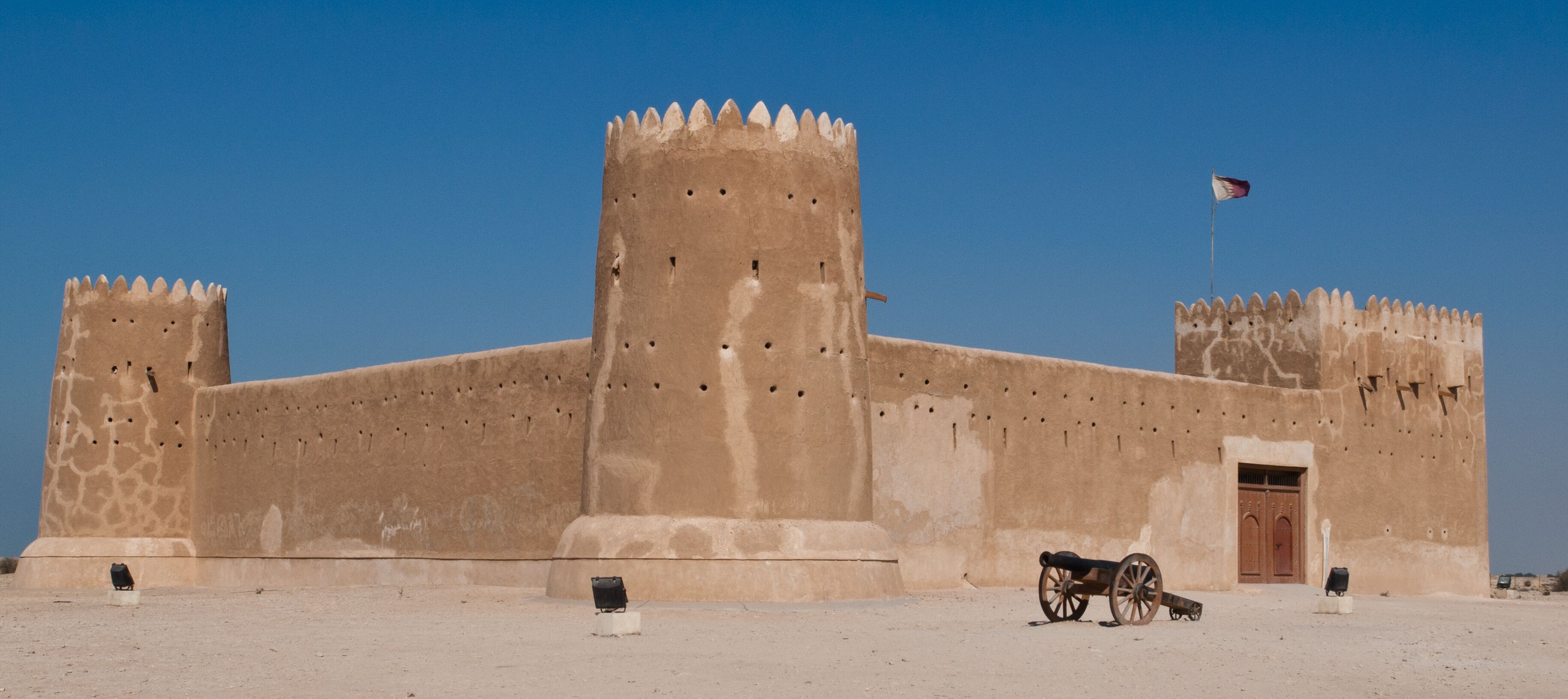 A large fort with two towers and a flag.