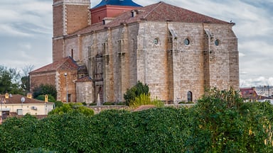 Uma igreja histórica com uma torre de sino imponente e uma cúpula azul.