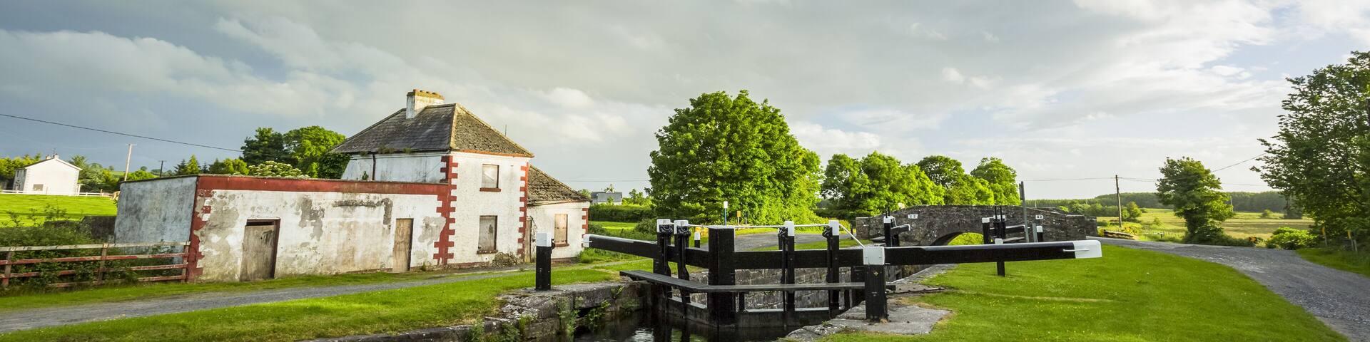 Old red and white house beside a lock on the grand canal in Kildare on a summer evening; Rathangan, County Kildare, Ireland