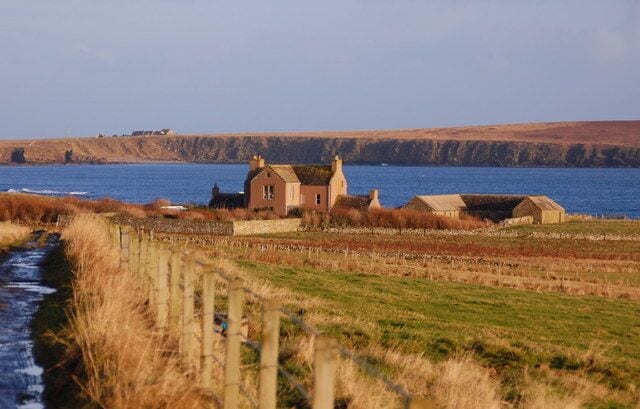 A coastal house with a view of the sea and cliffs.