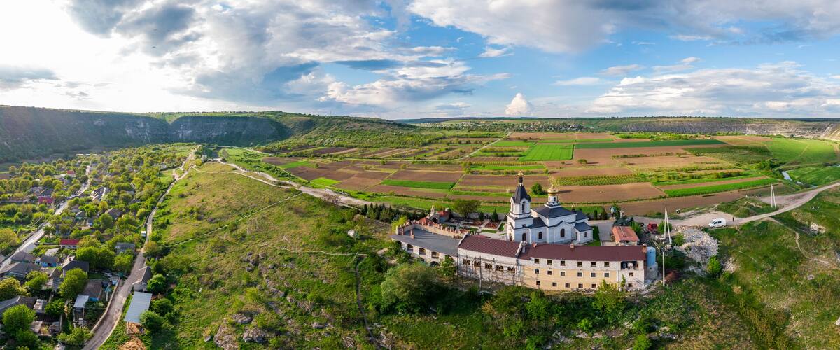 A castle surrounded by fields and a valley.