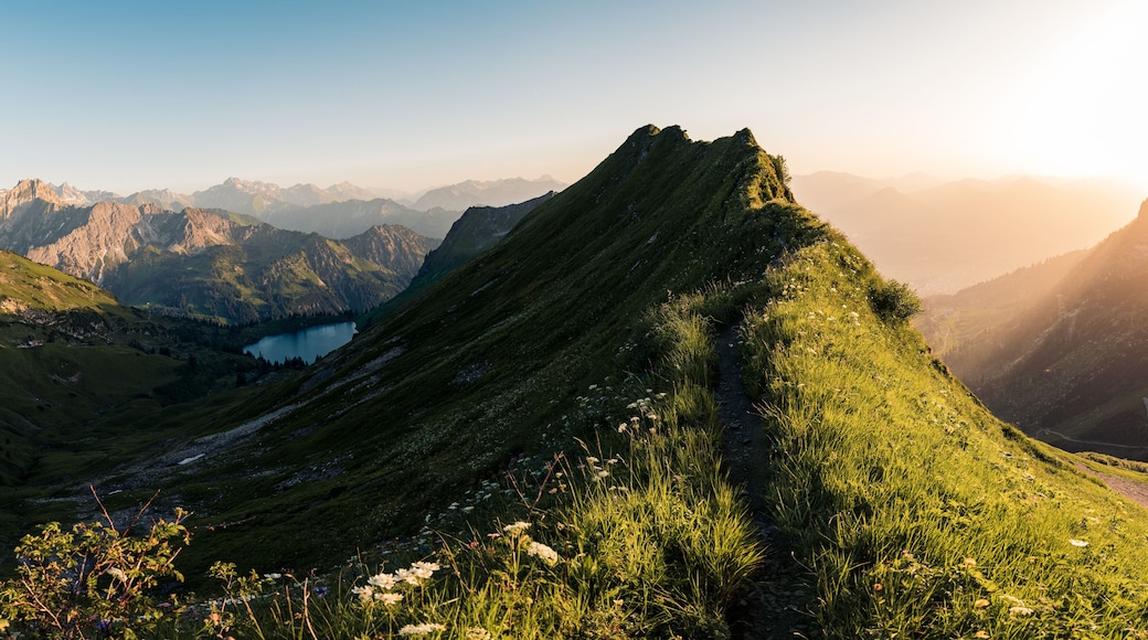 A mountain landscape with a prominent peak, a valley, and a lake.