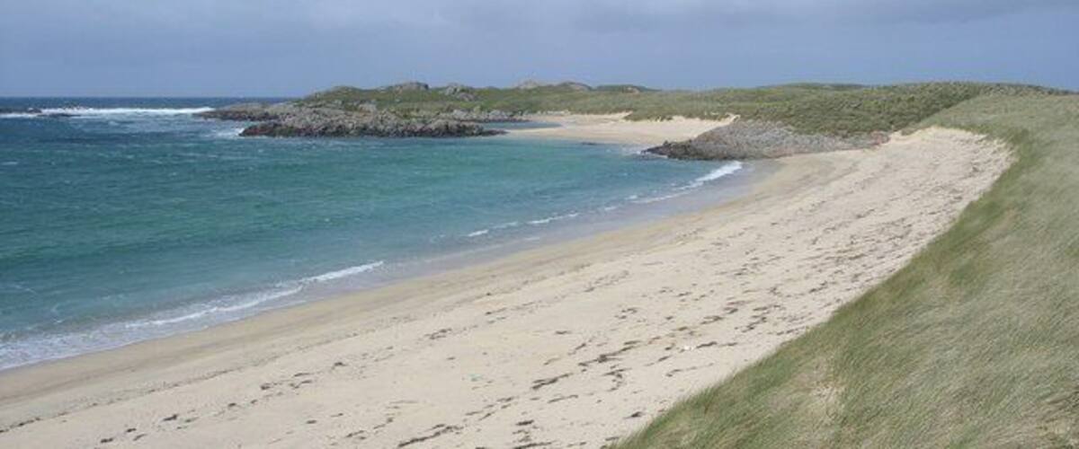Traigh nan Siolag, Coll View northwestwards over the beach Traigh nan Siolag from a position just above the beach. In the middle distance, at the end of the small spit of sand is the tiny tidal islet Eilean an Fheoir.