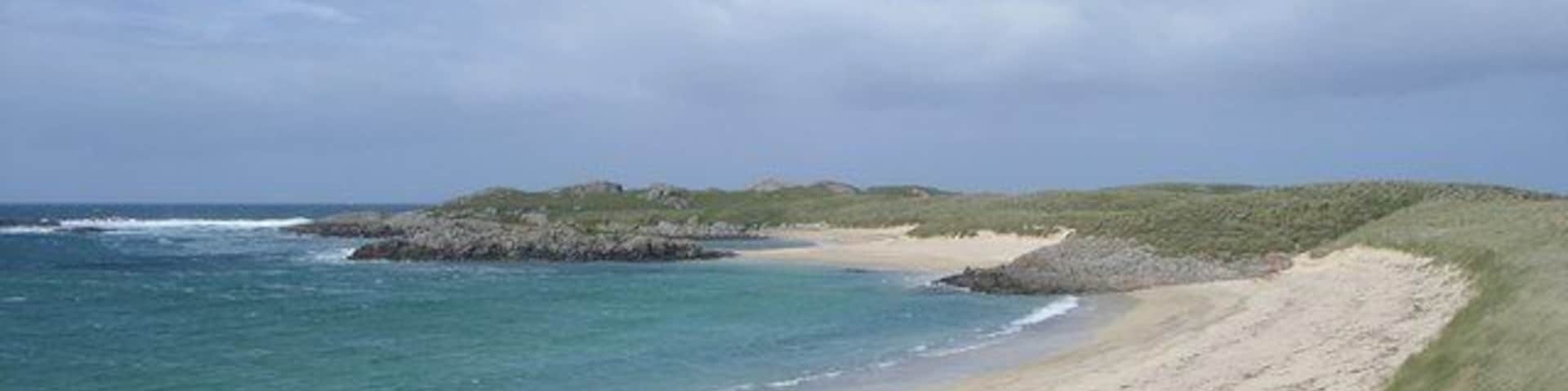 Traigh nan Siolag, Coll View northwestwards over the beach Traigh nan Siolag from a position just above the beach. In the middle distance, at the end of the small spit of sand is the tiny tidal islet Eilean an Fheoir.