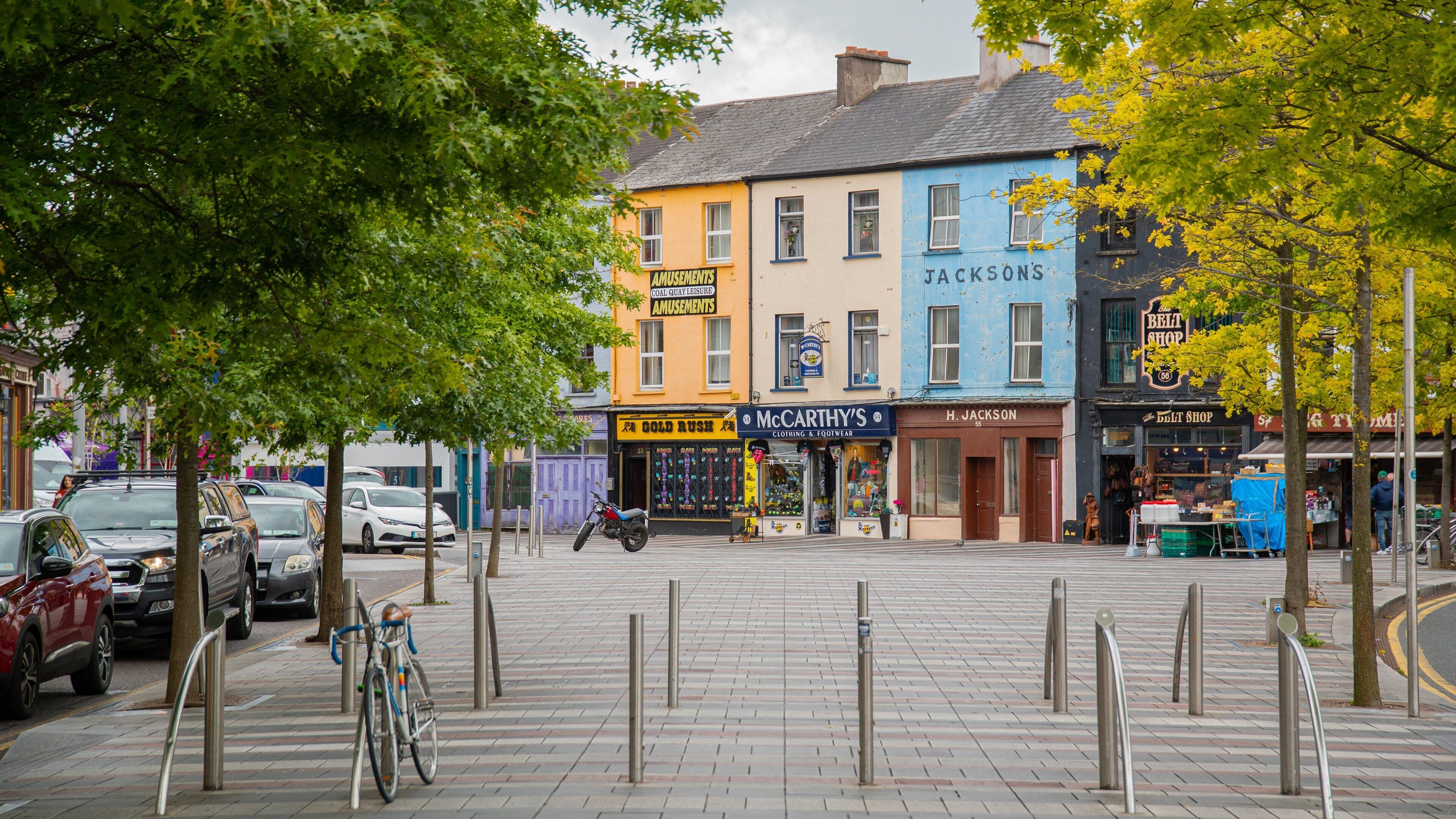 A street with colorful buildings, including a blue one with 'Jackson's' and a yellow one with 'Amusements'.