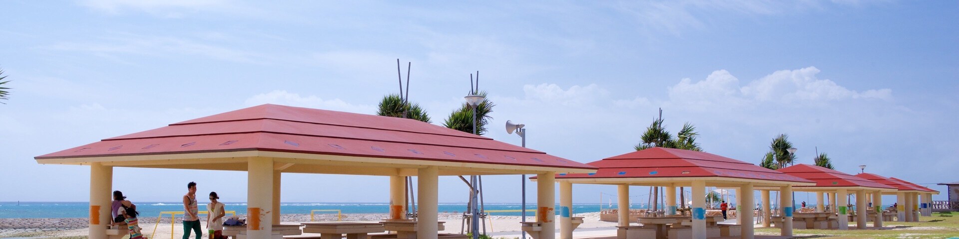 Sombrillas de playa, arena y el océano.