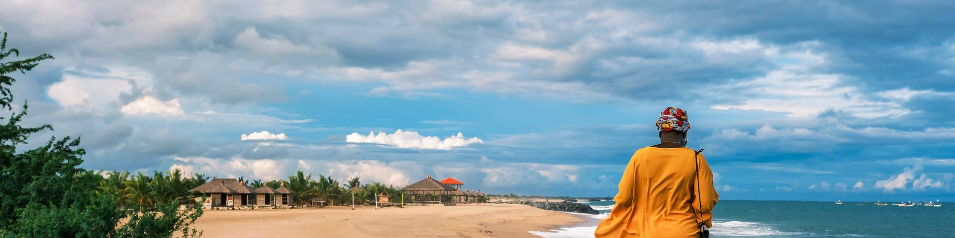 African woman standing on the edge of a beach in the tropical part of Africa, Keta Ghana