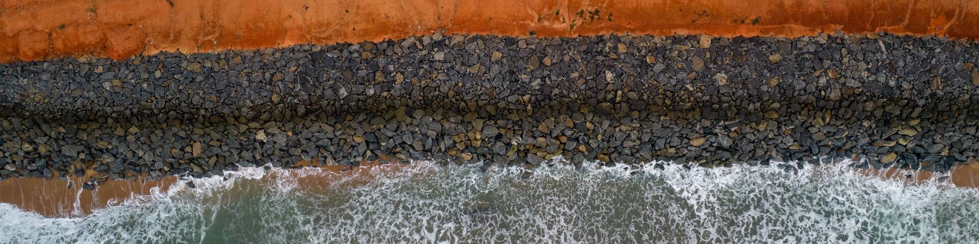 A rocky shoreline with waves crashing against it.