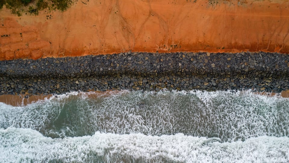 A rocky shoreline with waves crashing against it.