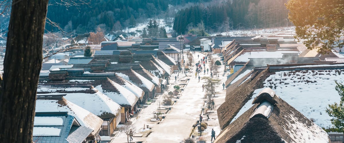 A snow-covered village with traditional houses and a central path.