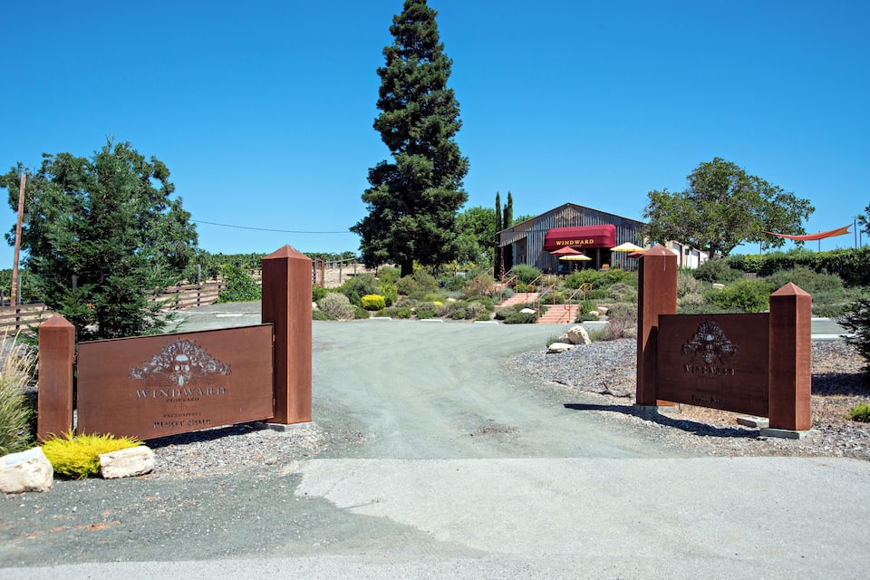 A winery entrance with a sign reading "Windward Vineyards Pinot Noir."