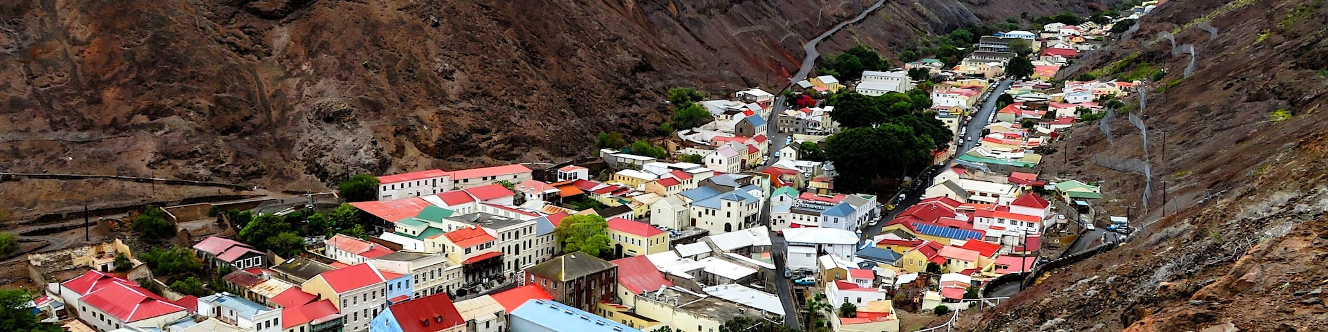 Jamestown, Saint Helena - Nestled between towering valley walls. This stunning image showcases the unique landscape and vibrant architecture of this remote island.