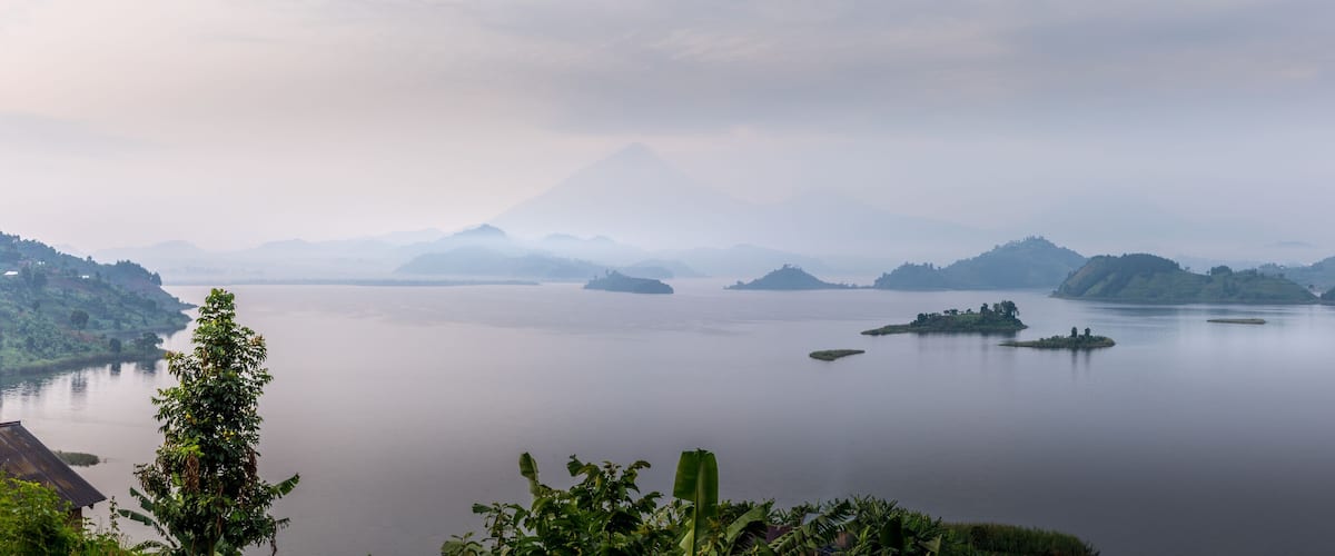 A calm lake with several small islands and a mountain in the background.