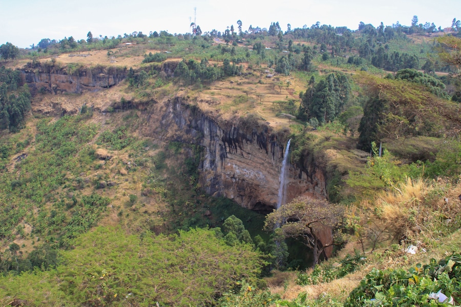 Tall and thin Sipi Falls flowing among rocks in Uganda