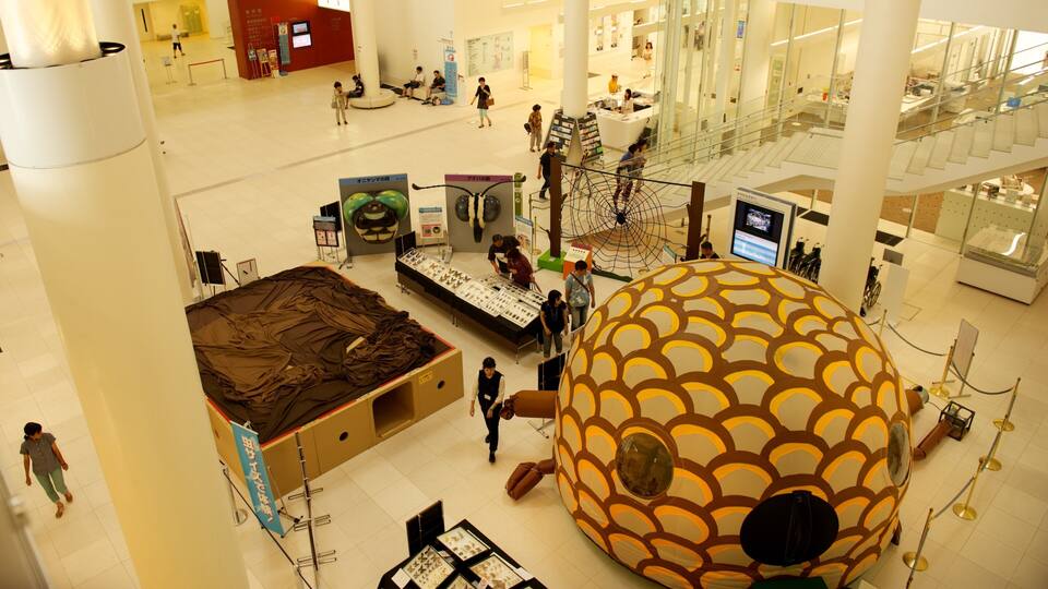 A large indoor space with a prominent spherical structure, various display tables, and people walking around.