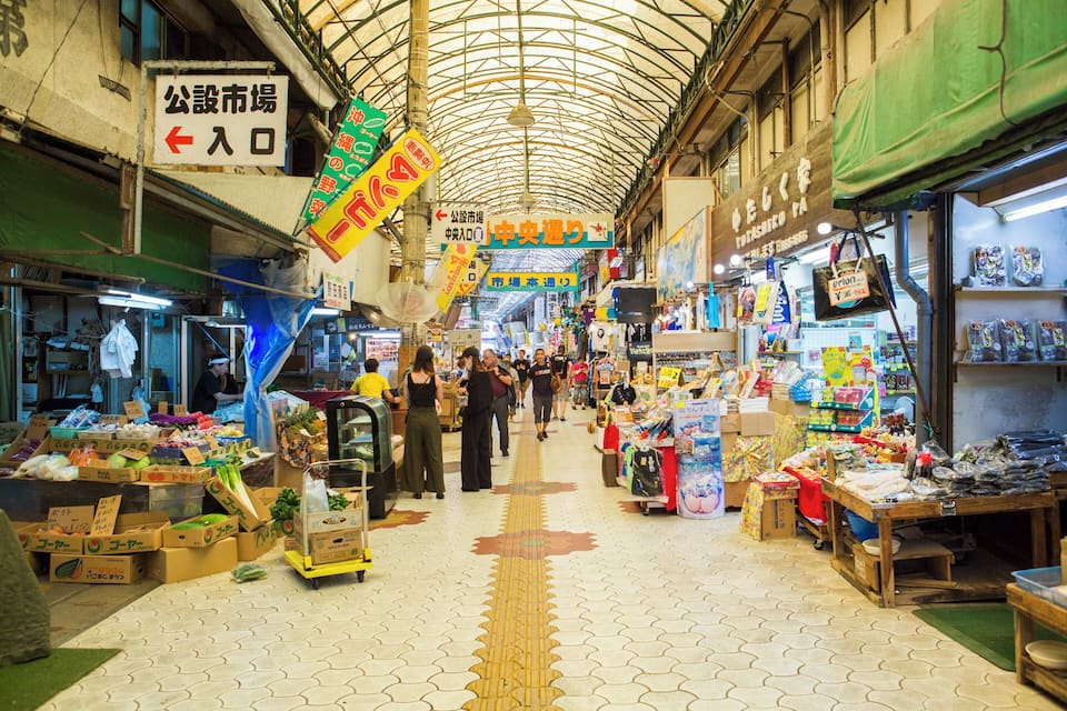 A bustling indoor market with various stalls selling goods.