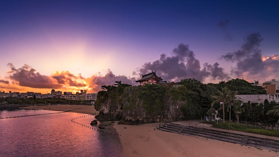 Sunrise landscape of the Shinto Shrine Naminoue at the top of a cliff overlooking the beach and ocean of Naha in Okinawa Prefecture, Japan.