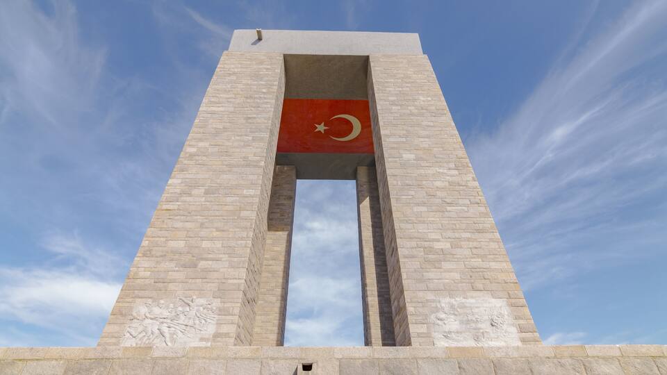 A tall monument with a flag.