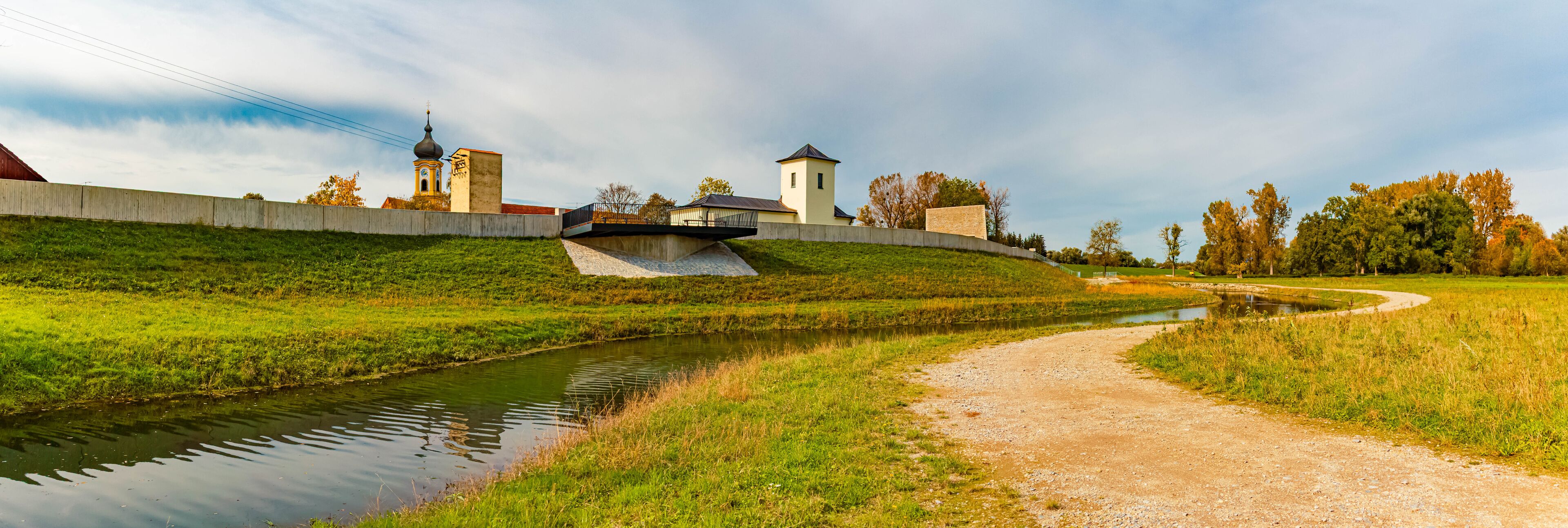 A river, a bridge, and a church with a bell tower.