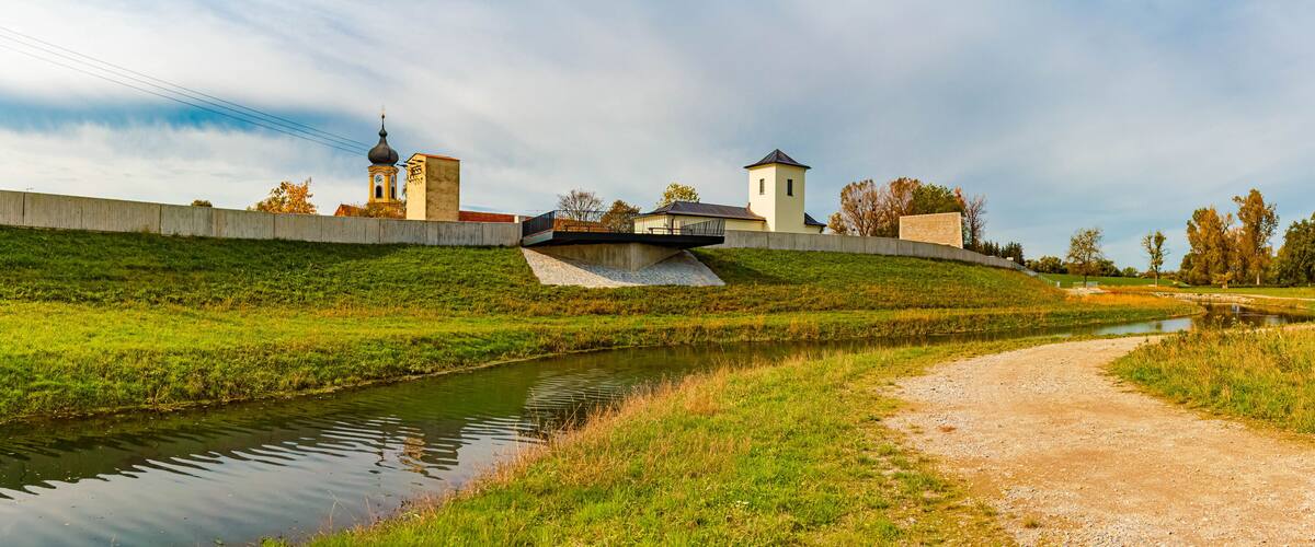 A river, a bridge, and a church with a bell tower.