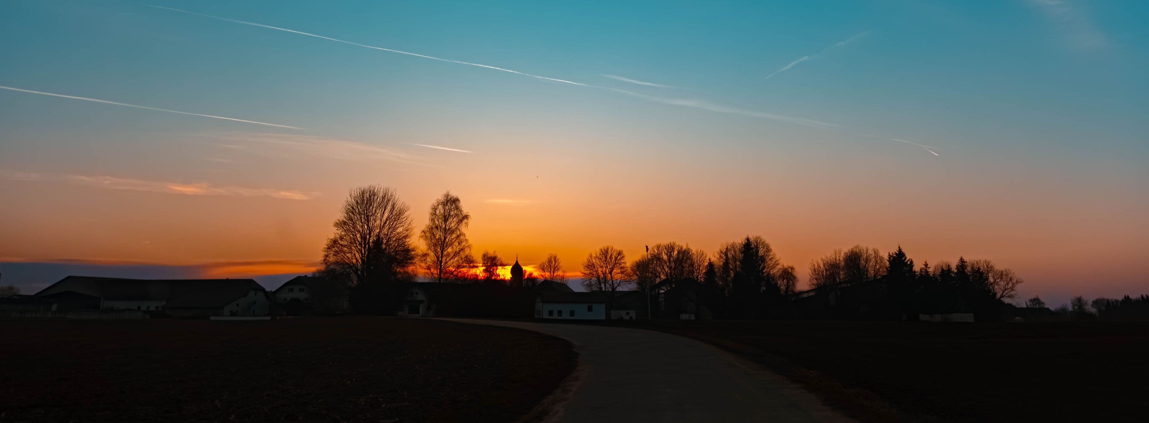 Spring sunset or sundowner with a church silhouette seen from near Arbing, Osterhofen, Deggendorf, Bavaria, Germany
