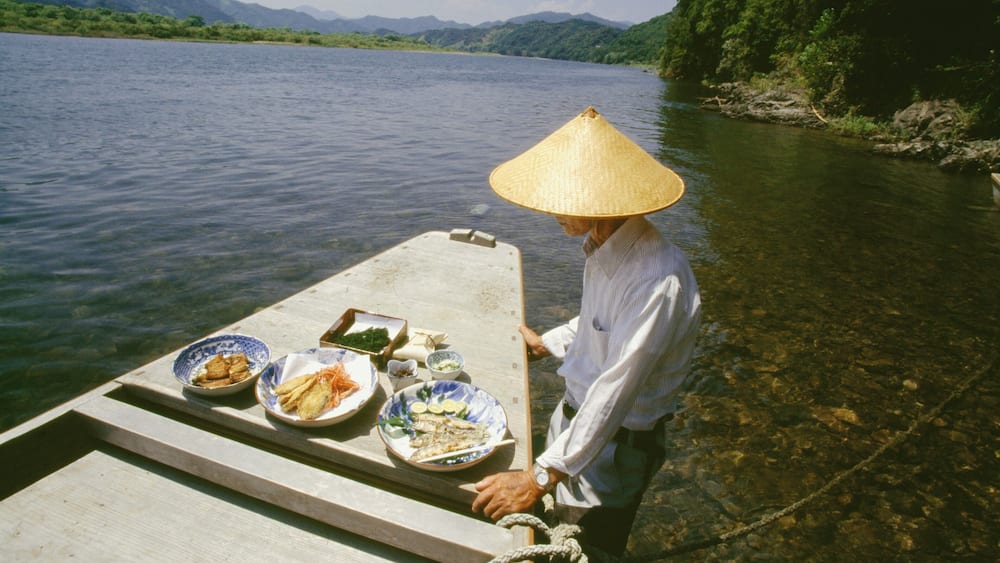 Mature man standing near a boat, Shimanto River, Kochi, Shikoku, Japan