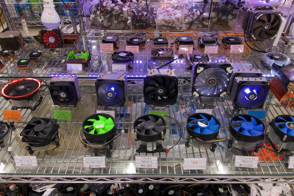 A variety of computer cooling fans on display with price tags.