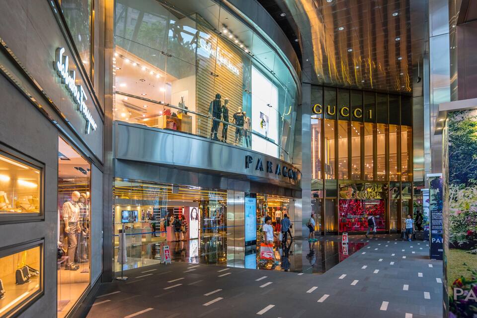 Un centre commercial moderne qui abrite des boutiques comme GUCCI et PARIS LA COMTE.