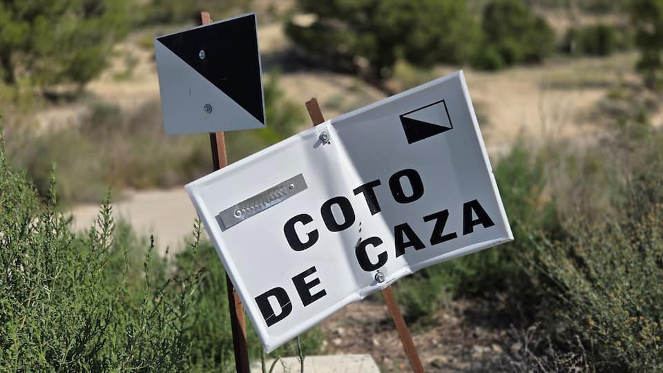 A sign with 'COTO DE CZA' and a triangular warning sign.