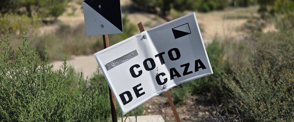 A sign with 'COTO DE CZA' and a triangular warning sign.