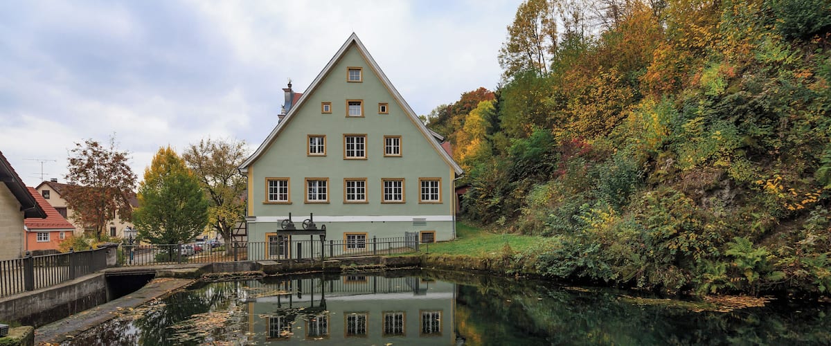Königsbronn, Baden-Württemberg, Germany: "Brenztopf" the spring of river Brenz. In the background the historic town hall.