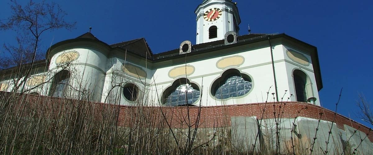 A church with a clock tower and a steeple under a clear blue sky.