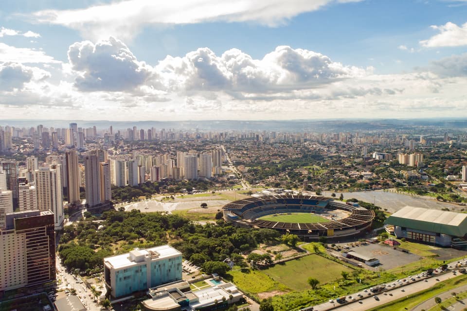 A cityscape with a large stadium surrounded by high-rise buildings and a clear sky.