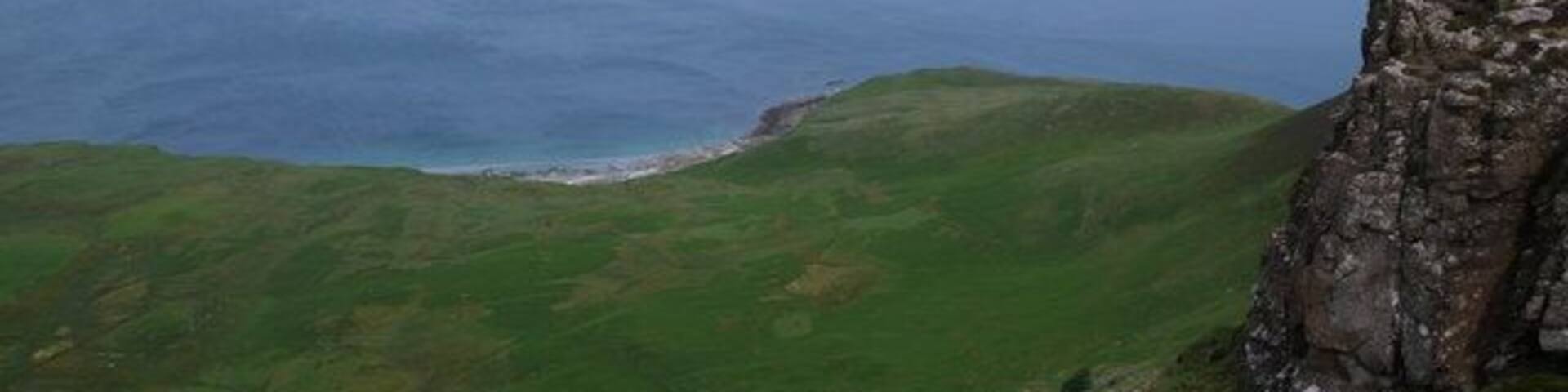 Edge of Beinn Bhuidhe. A steep sided escarpment overlooking Five Pennies (Cuig Peighinnean; in the foreground), and Howlin (to the left), part of the wider crofting community of Cleadale.