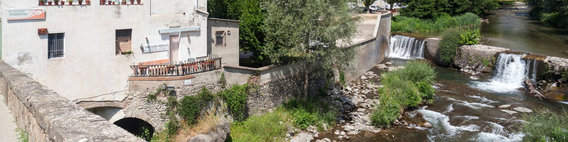 Village view, bridge and Freser river in catalan village of Campdevanol, province Girona, Catalonia.Spain.