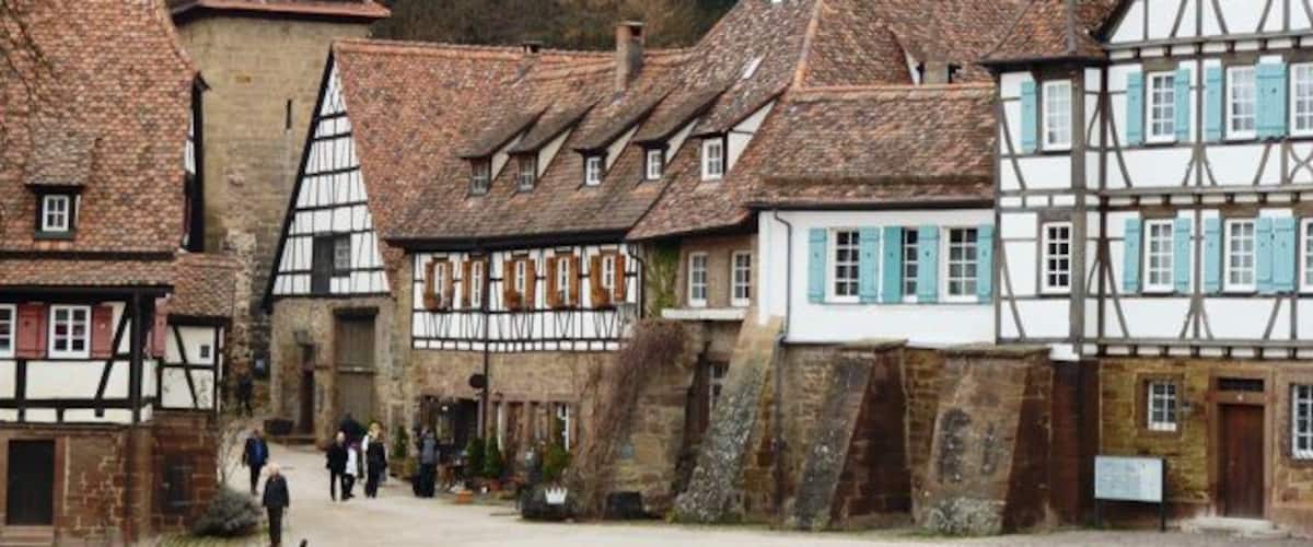 A traditional European village with timber-framed houses and a cobblestone street.