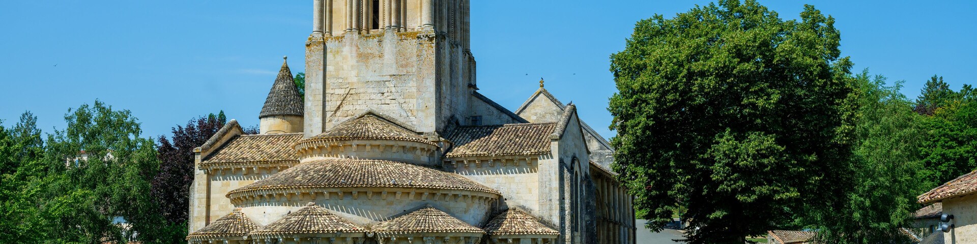 Uma igreja histórica com uma alta torre de sino e telhado telhado.