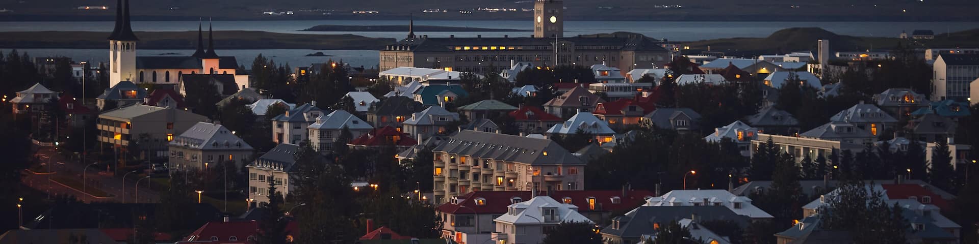 Beautiful night dusk view of Reykjavik, Iceland, aerial view with Hallgrimskirkja lutheran church, with scenery beyond the city, Esja mountain and Faxafloi bay
