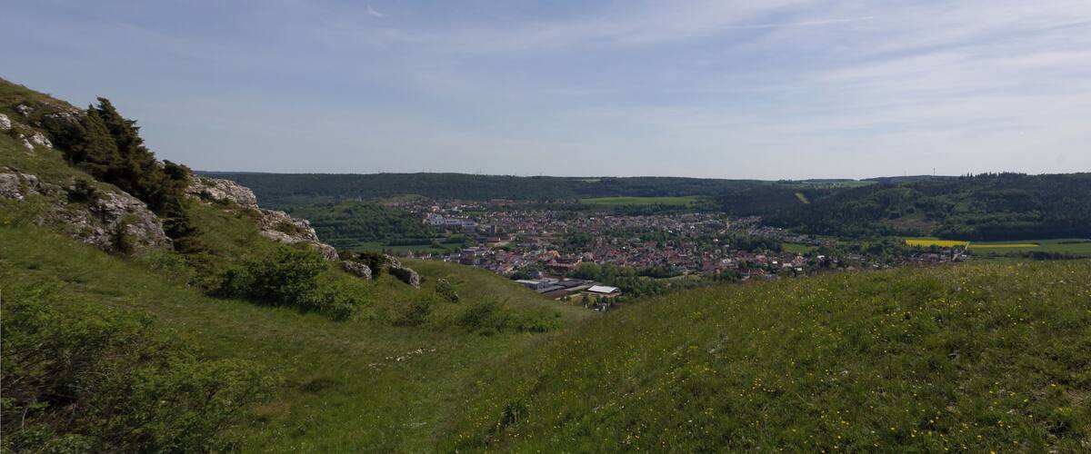 A valley with a town, green hills, and a clear sky.