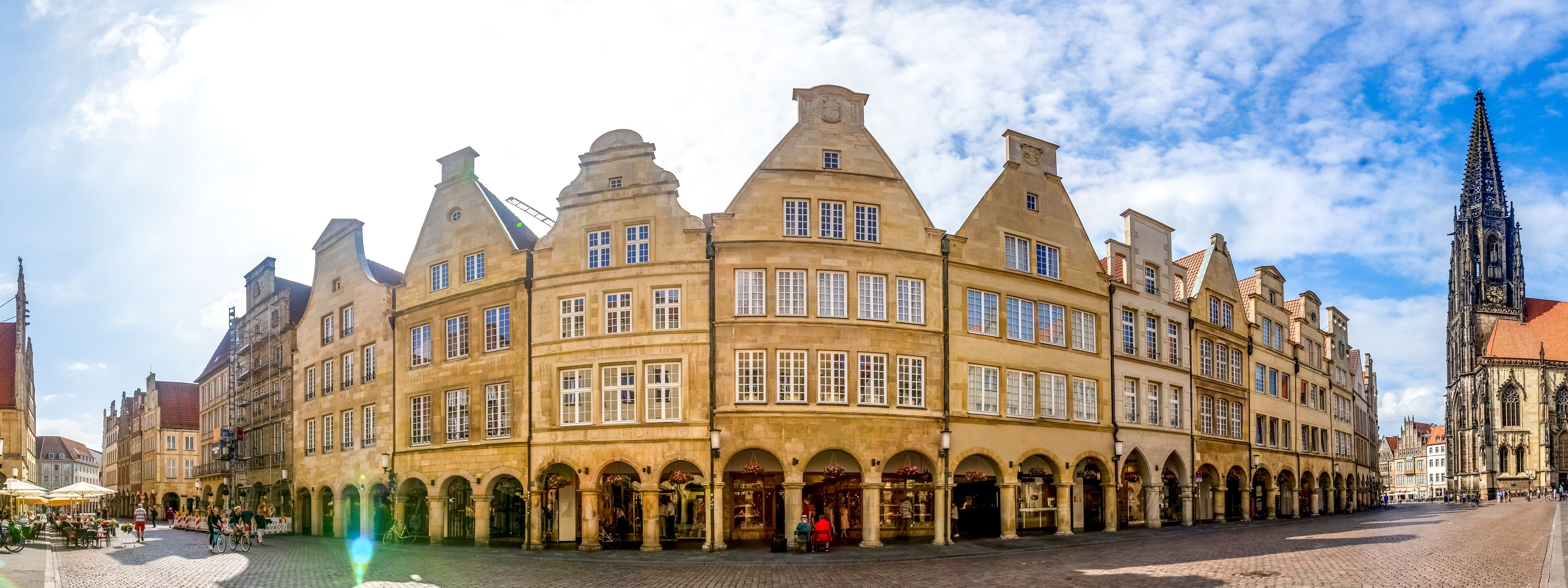 A historic building with arched windows and a clock tower in the background.