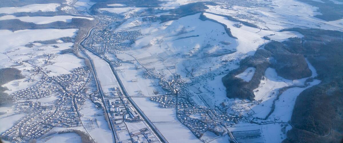 An aerial view of a snow-covered town with a river running through it.