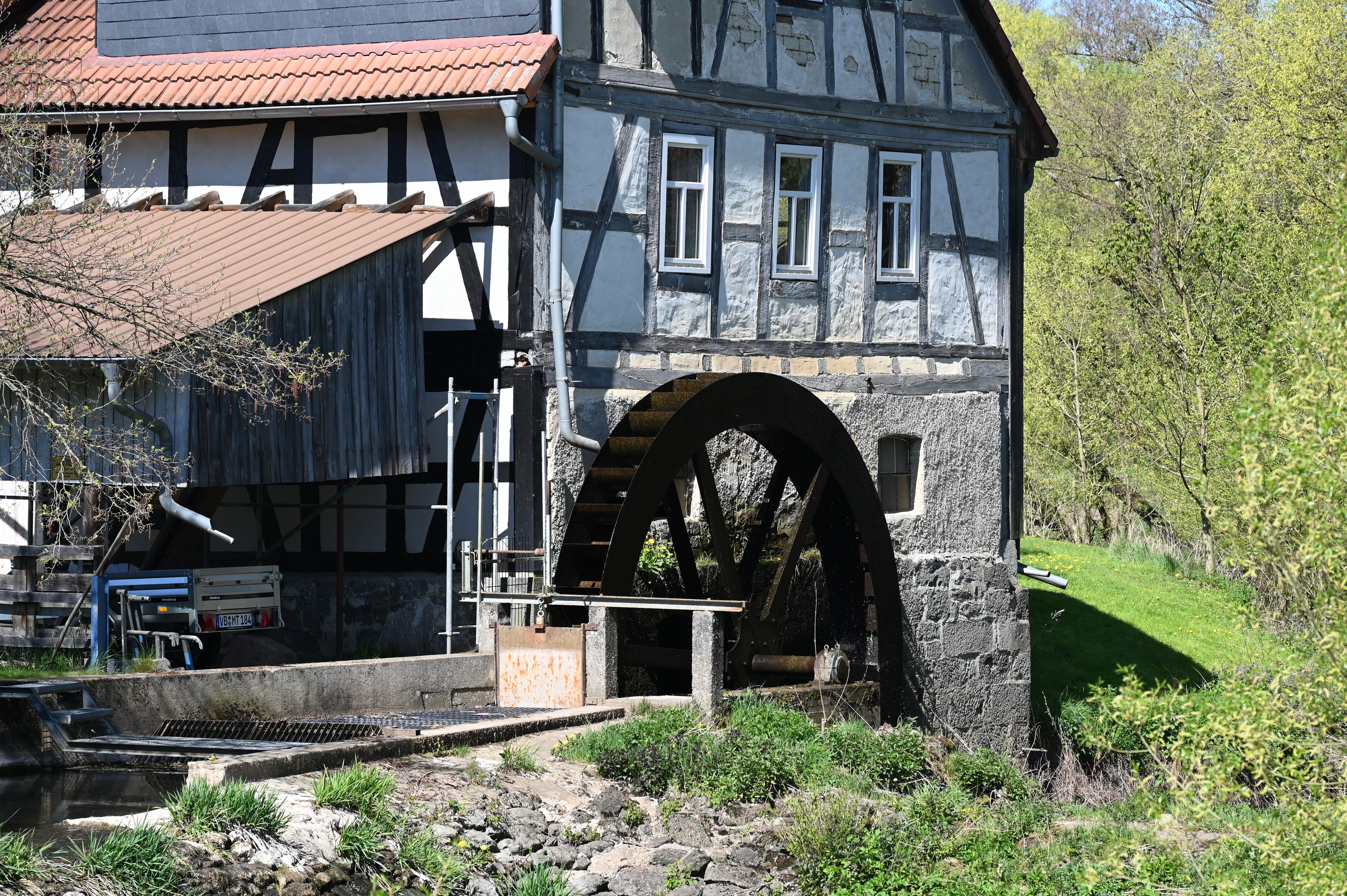 A traditional half-timbered house with a large water wheel.