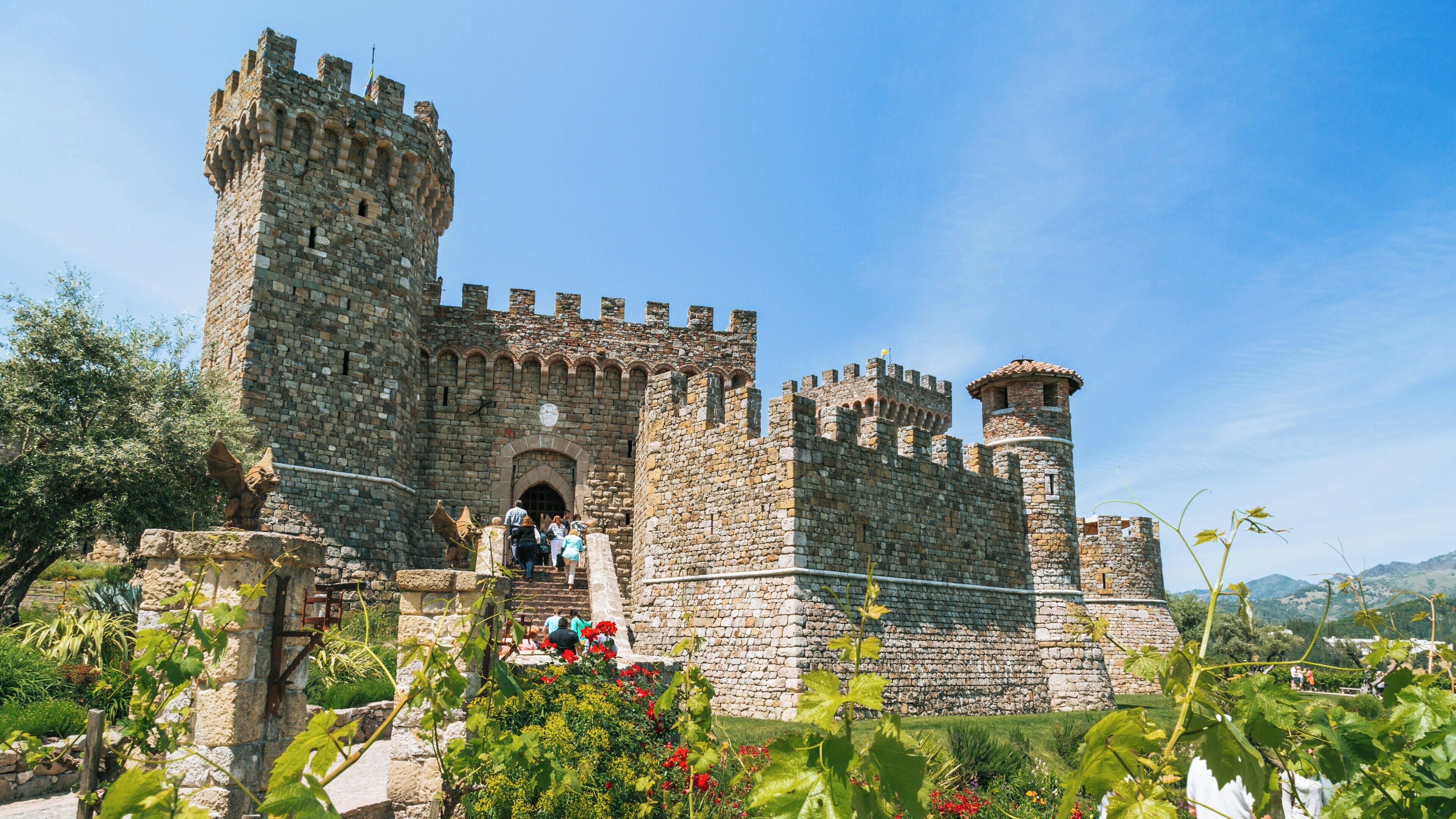Castello di Amorosa in Calistoga showcases medieval architecture and beautiful landscaping under a bright blue sky