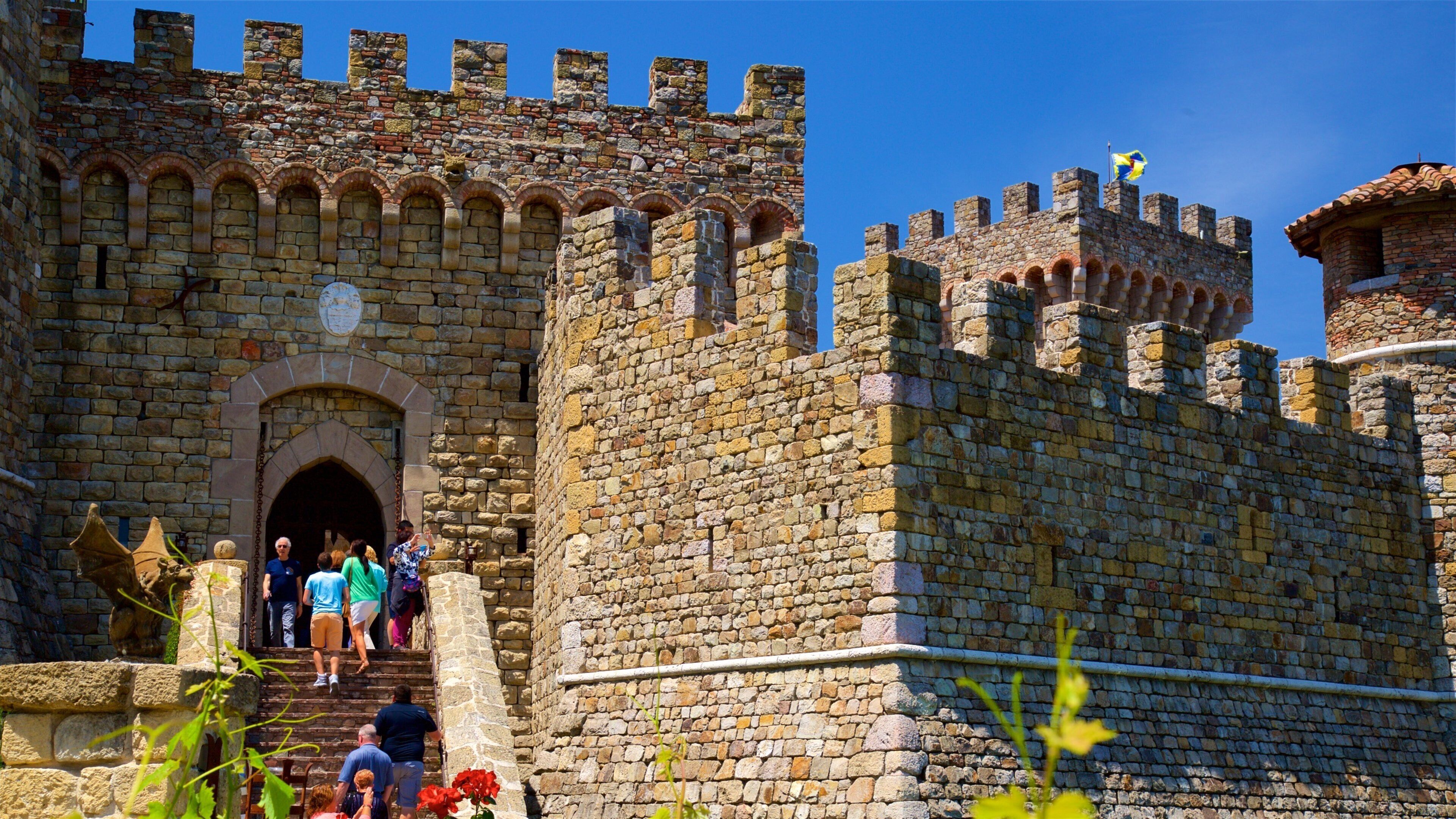 Castello di Amorosa featuring heritage elements and chateau or palace as well as a small group of people