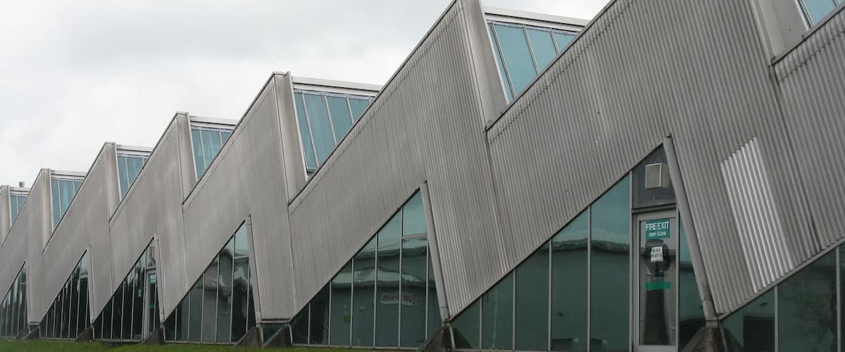 A modern building with a zigzag roof design and large windows.