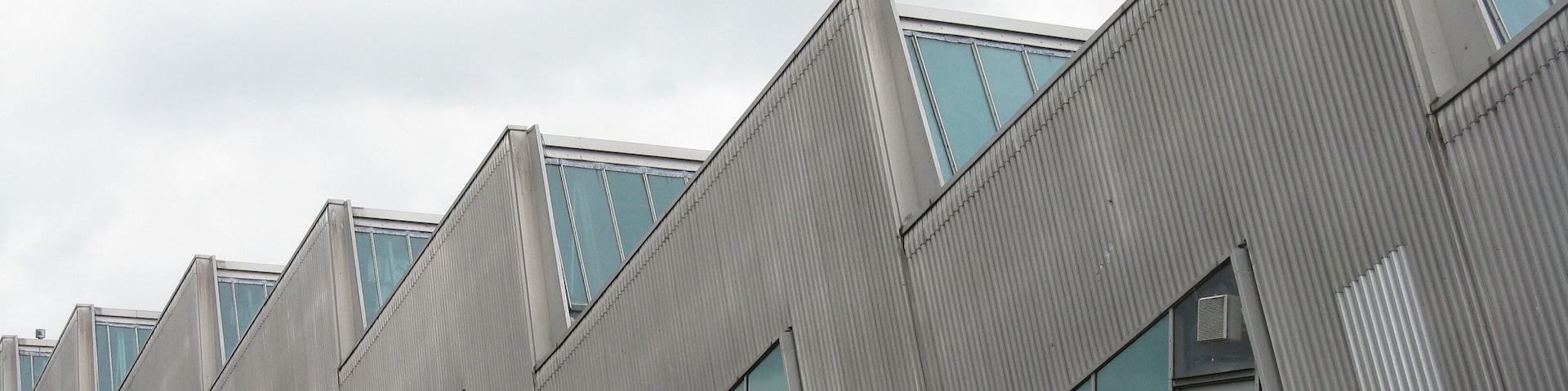 A modern building with a zigzag roof design and large windows.