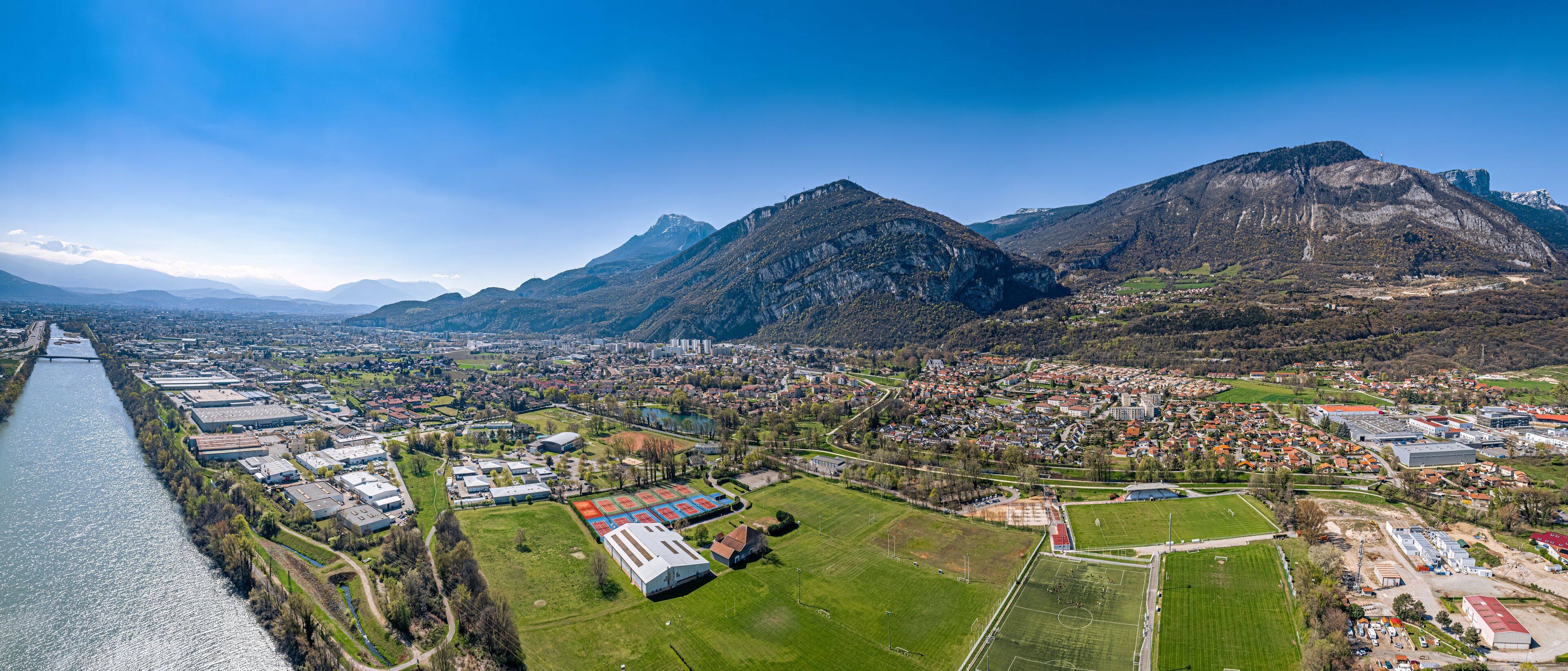 A river, industrial buildings, residential areas, and mountains.
