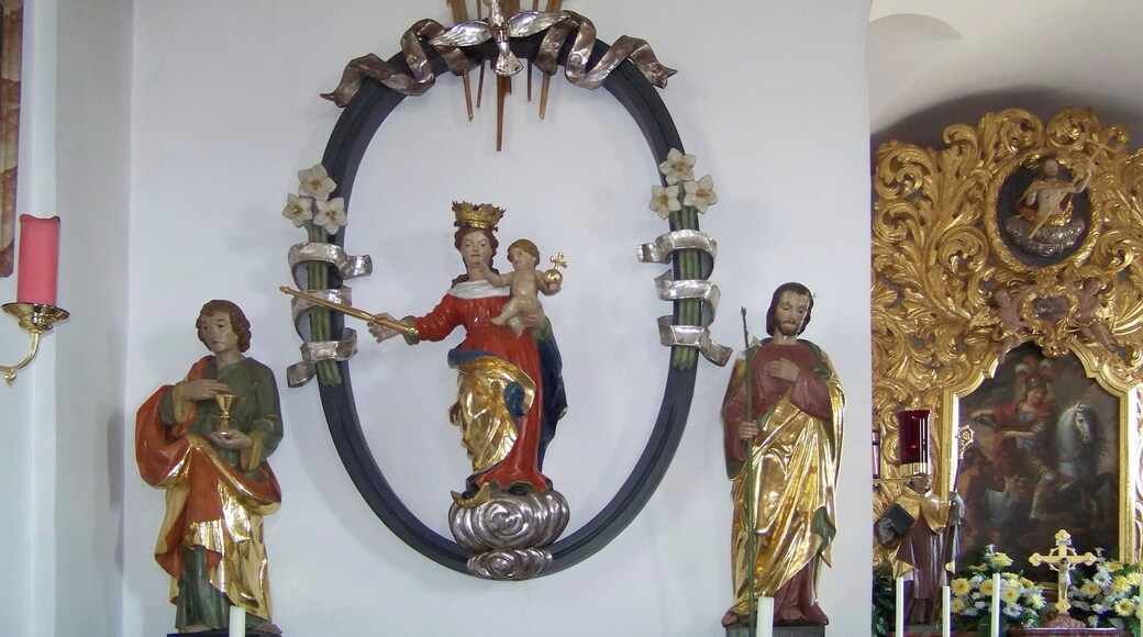 Bad Abbach, Dünzling, Marienplatz 4. Katholische Kirche St. Martin. Mittelalterlich, 1711/12 erweitert, Turmaufbau 1712. Linker Seitenaltar St. Maria. Figur Patrona Bavaria im ovalen Rahmen, um 1510. Darüber zeigt die Hand Gottes aus einer Wolke auf den Heiligen Geist, der als silberne Taube dargestellt ist. Seitenfiguren links St. Johannes Evangelist mit Kelch und St. Josef mit Lilie rechts.