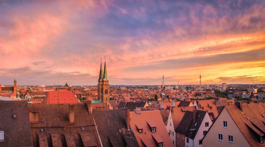 A cityscape with a prominent church spire and a tower with a spire.