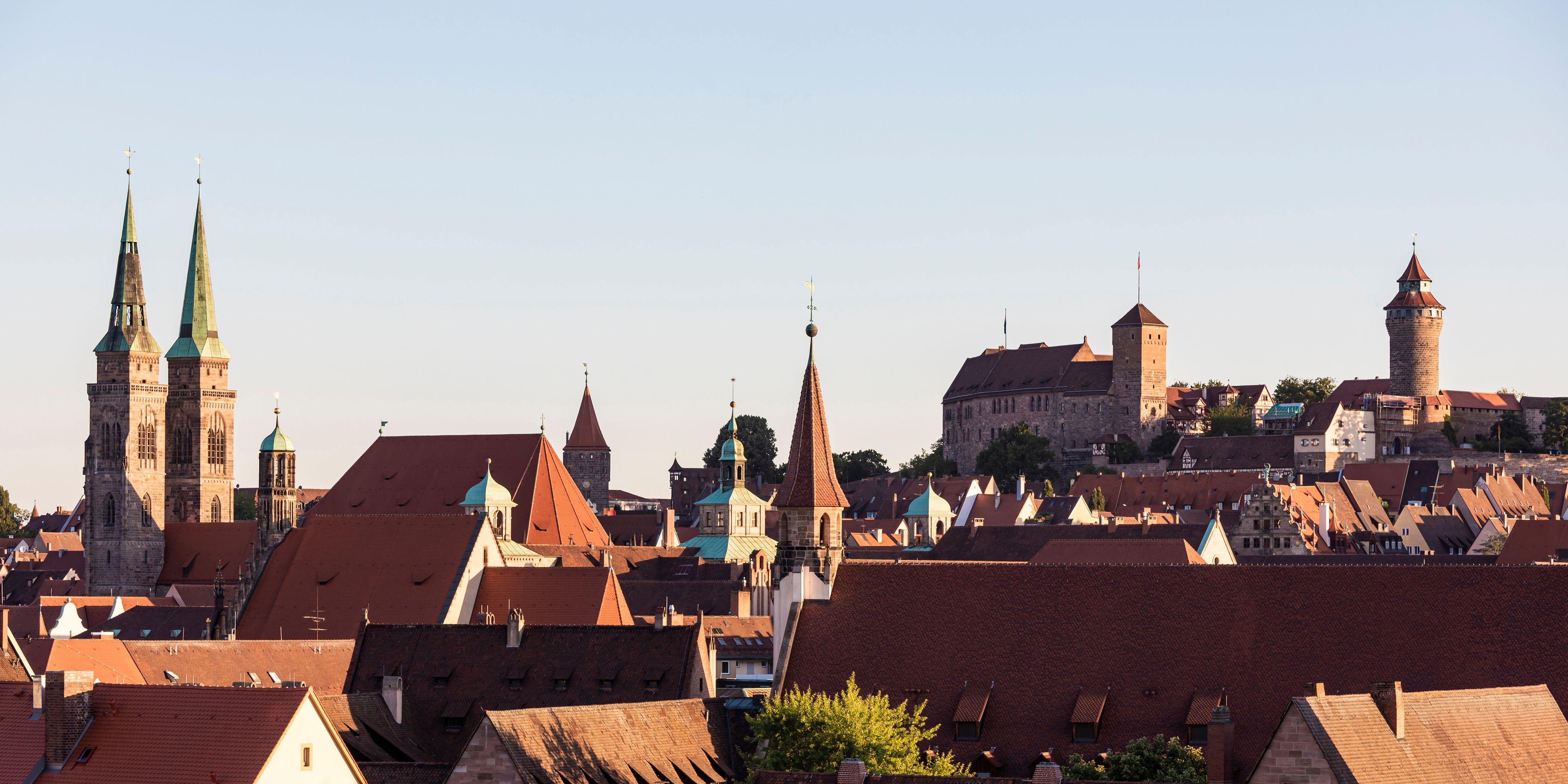A historic town with prominent church spires, a castle, and a mix of traditional and modern architecture.